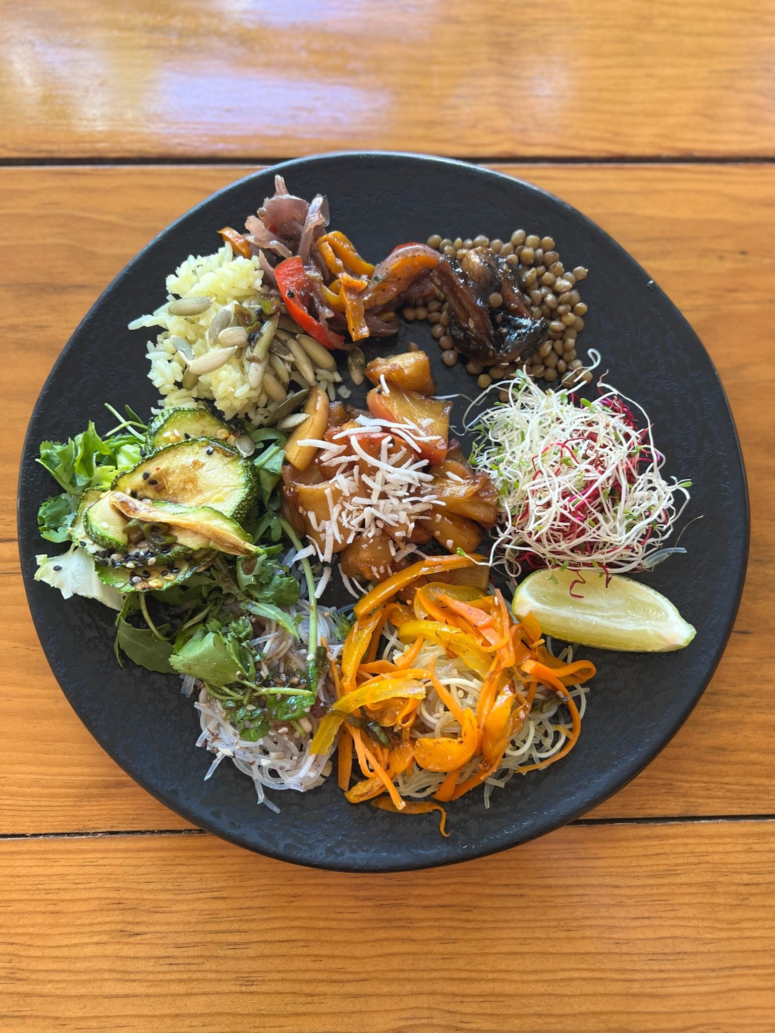 Top-down view of a plant-based protein bowl with rice, lentils, vegetables and sprouts, tracked in FitHub