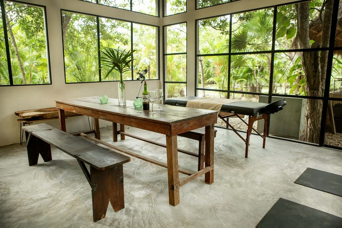 Dining and massage room with floor-to-ceiling windows at Rancho Verde Tulum