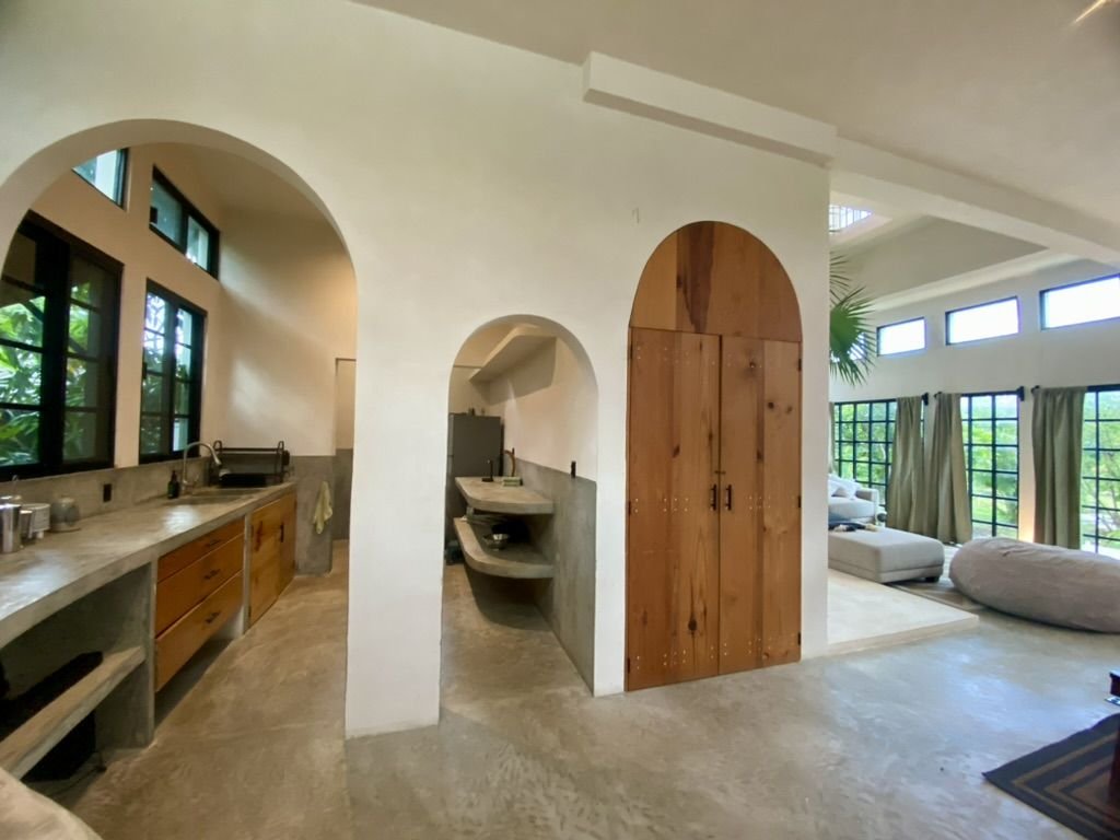 Kitchen with arches and living room at Rancho Verde Tulum