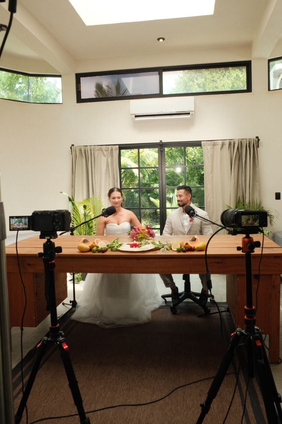 Couple at a wooden desk with cameras at Rancho Verde Tulum