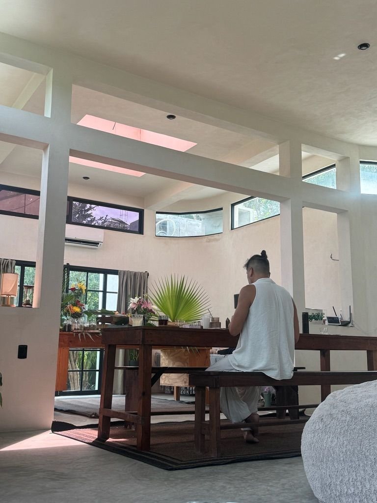 Retreat guest working at a wooden table at Rancho Verde Tulum